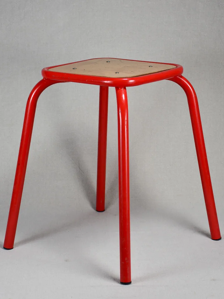 Set of ten red vintage stools from a school